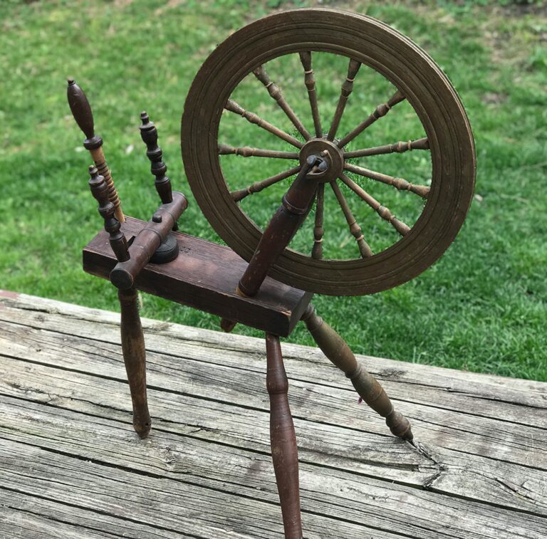 What should I look for when buying an antique spinning wheel?